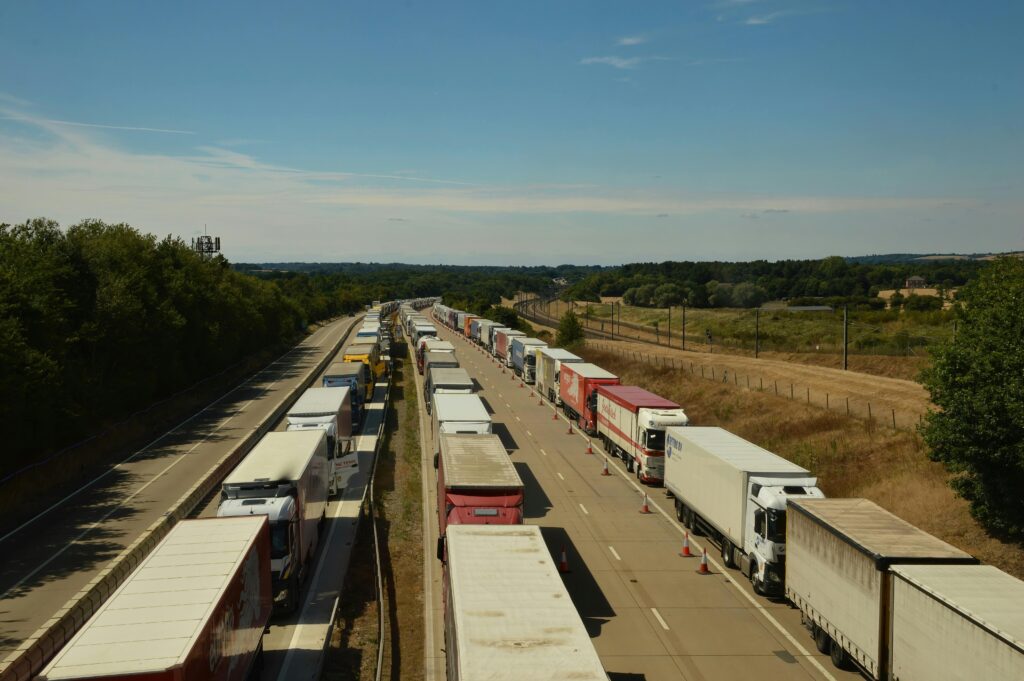 Services & Prices Aerial view of heavy traffic with trucks on an English highway under blue skies.
